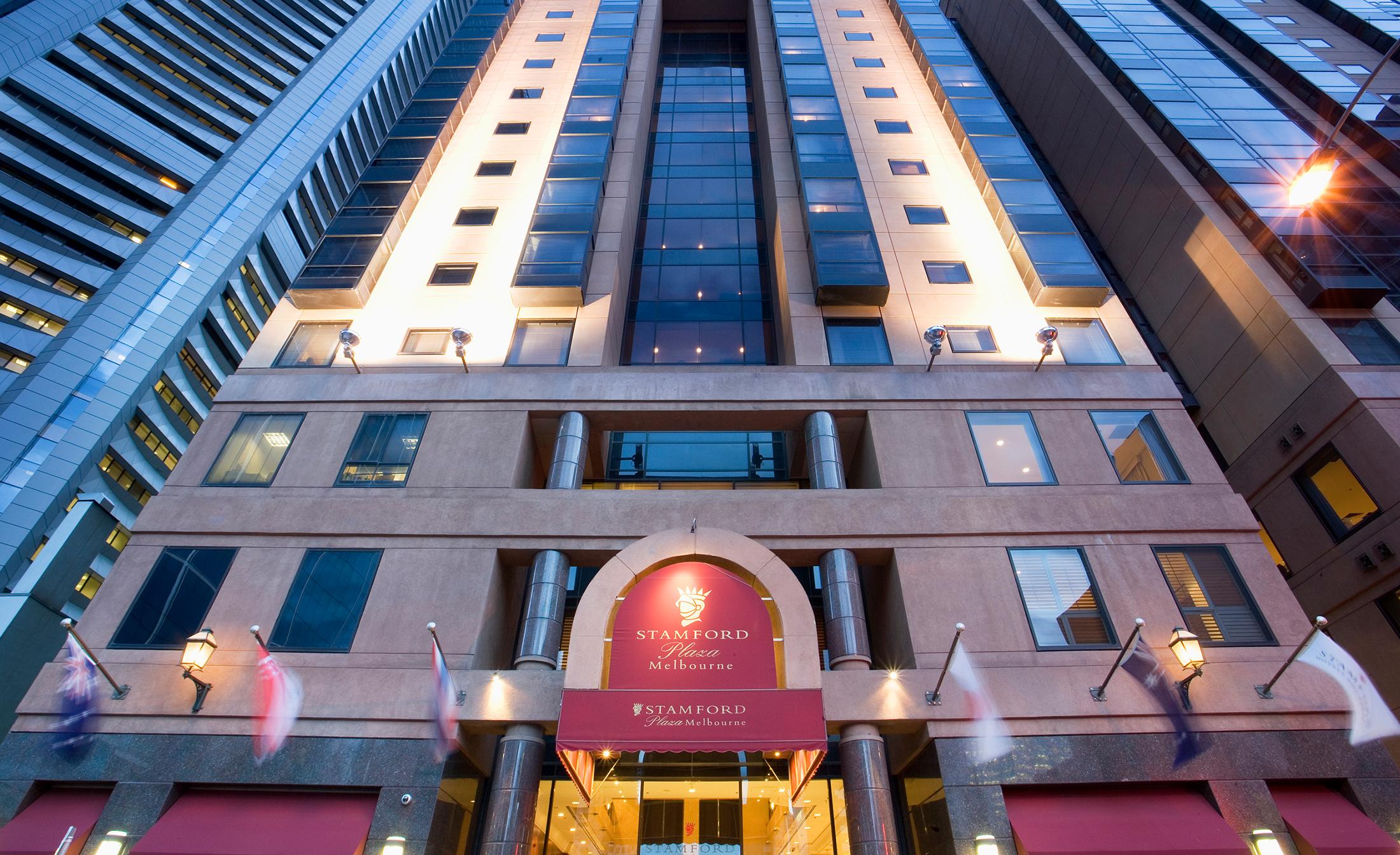 Stamford Plaza Melbourne Hotel Eksteriør billede The photo shows the entrance of a modern hotel building. The architecture features a tall structure with glass and stone elements. The hotel's name is visible above the entrance, which is framed by an arch, and the facade includes multiple levels wit
