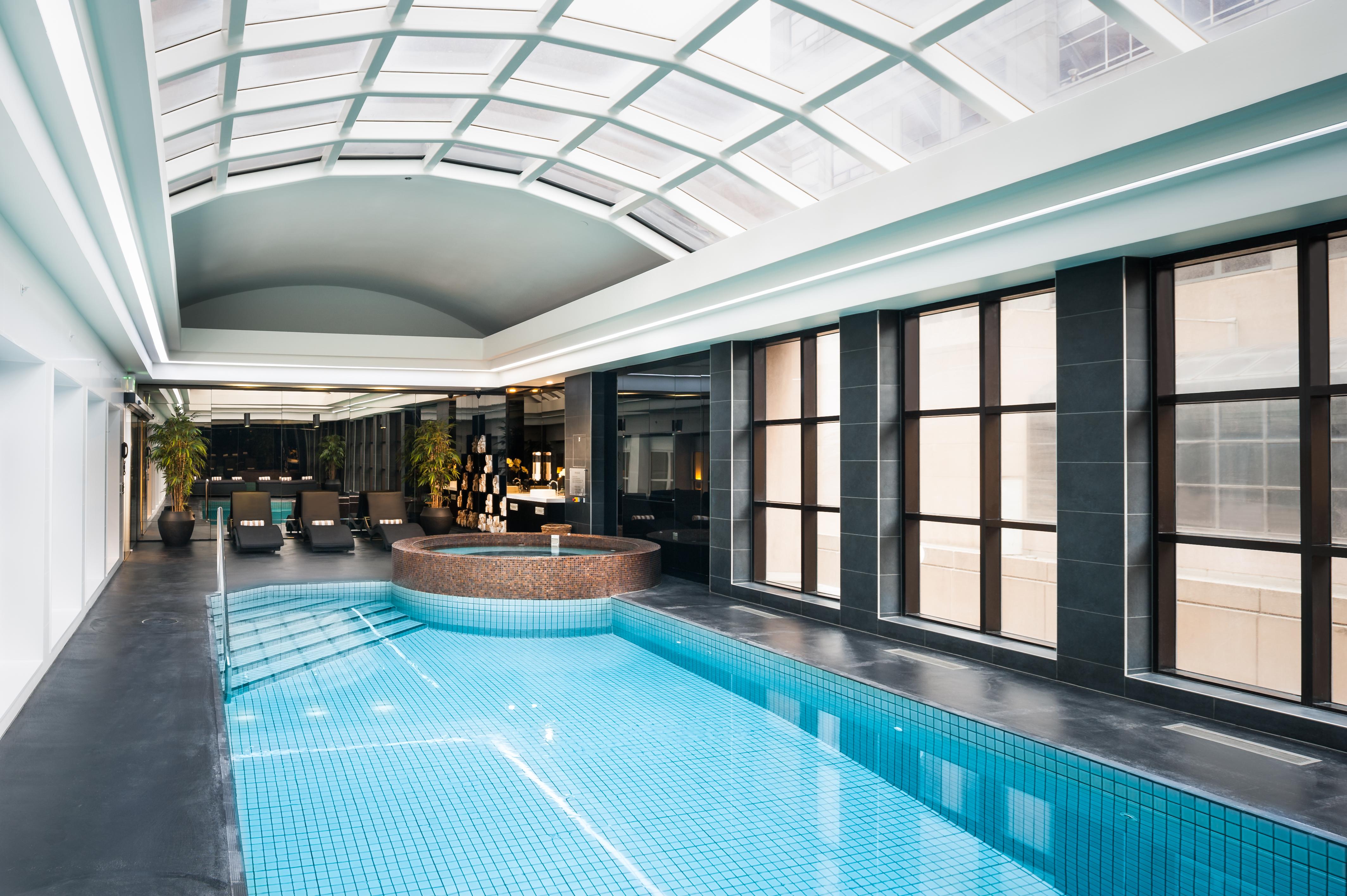 Stamford Plaza Melbourne Hotel Eksteriør billede The photo shows an indoor swimming pool area with a modern and sleek design. The pool is rectangular and features bright blue tiles. Above the pool, there's a large, transparent glass ceiling that allows natural light to flood the space. Surrounding 