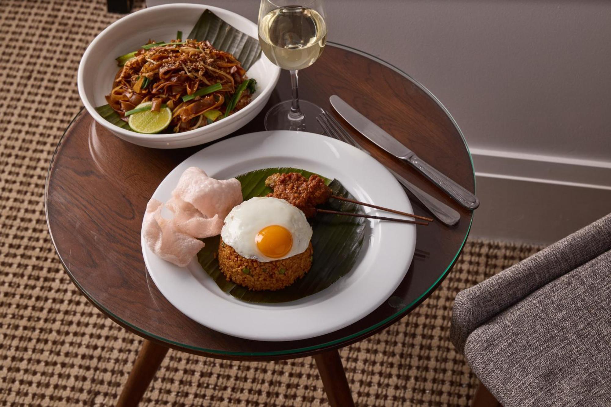 Stamford Plaza Melbourne Hotel Eksteriør billede The photo shows a beautifully arranged meal on a wooden side table. On a white plate, there is a serving of fried rice, topped with a sunny-side-up egg, accompanied by prawn crackers. The dish also features a small portion of what appears to be a spi