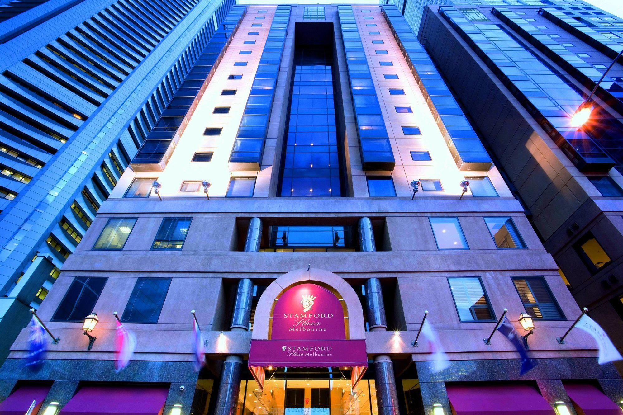 Stamford Plaza Melbourne Hotel Eksteriør billede The photo shows the exterior of a hotel, likely a luxury or high-end establishment. The building features a modern architectural design with a combination of glass and stone. The entrance is marked by a prominent sign, and the facade is illuminated, 
